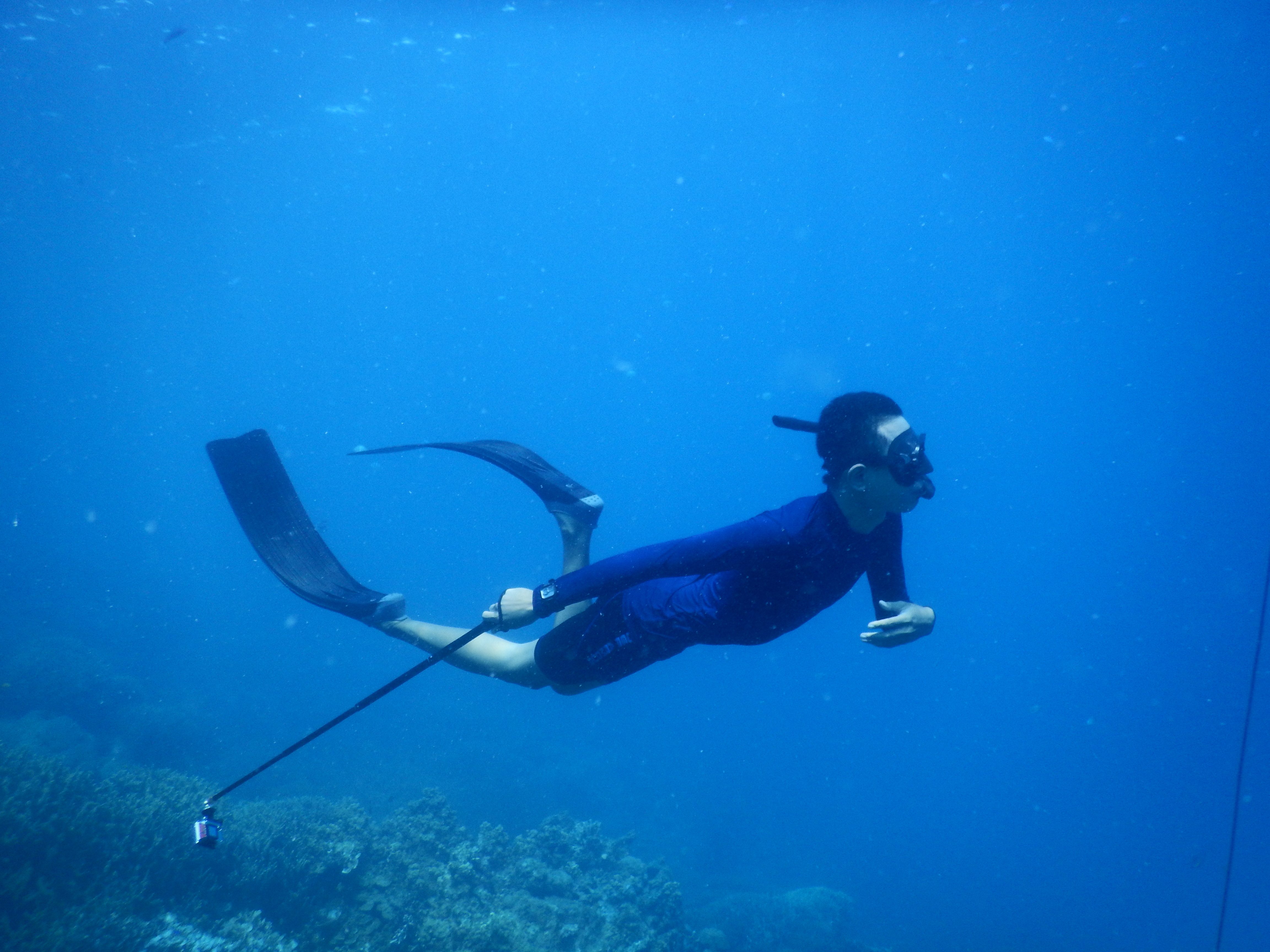 A freediver surrendering into calm, deep blue water